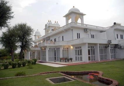 An exterior view of the Savista Retreat which shows a traditional Rajasthani-style white building with domes, balconies, and multiple windows.