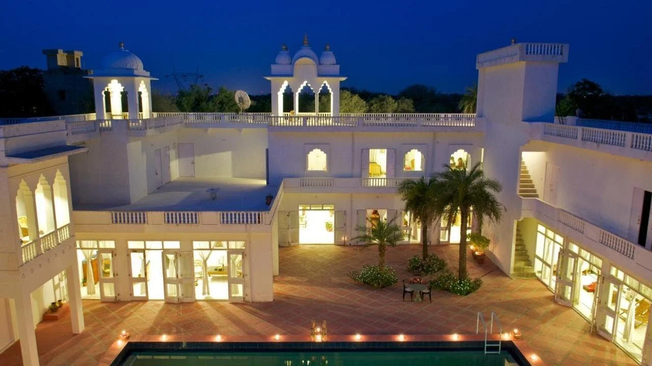 Savista Retreat, Jaipur, Rajasthan: White building lit at night with pool in foreground.