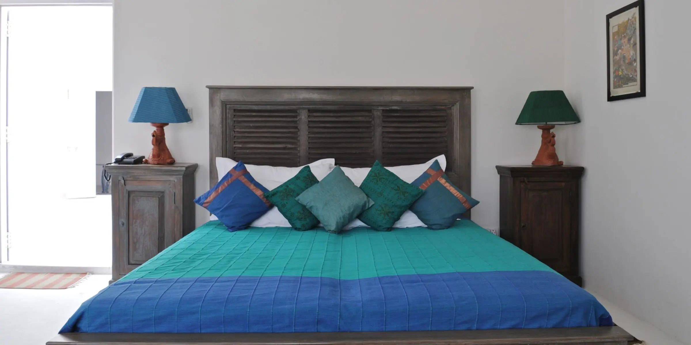 Cozy bedroom with blue lamps and colorful pillows