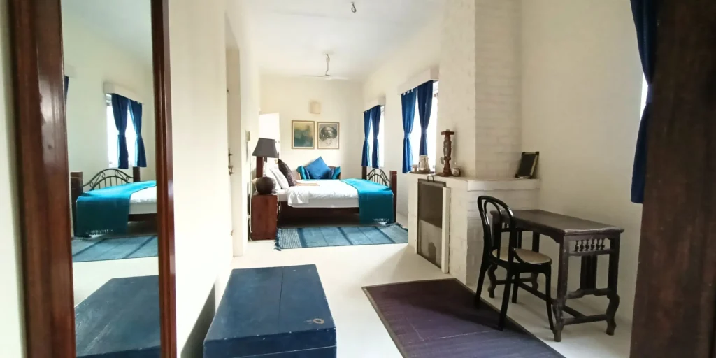 Cozy bedroom with blue curtains, wooden bed, and minimalist décor.