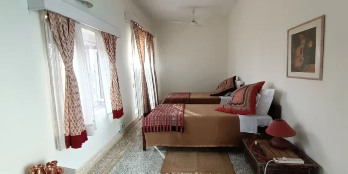 A cozy bedroom corner featuring a wooden wardrobe, a mirror, and a desk with some decorative items.