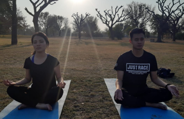 Two people doing yoga in open space