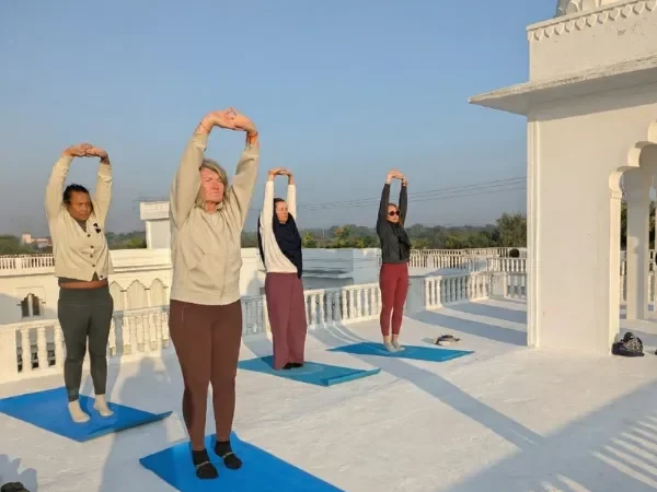 People doing yoga on rooftop with an Yoga Instructor