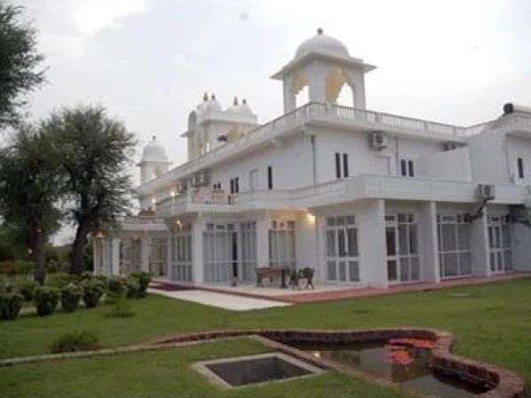 An exterior view of the Savista Retreat which shows a traditional Rajasthani-style white building with domes, balconies, and multiple windows.