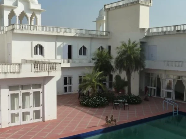 Exterior of Savista Retreat in Jaipur, featuring a white building with pool and courtyard.