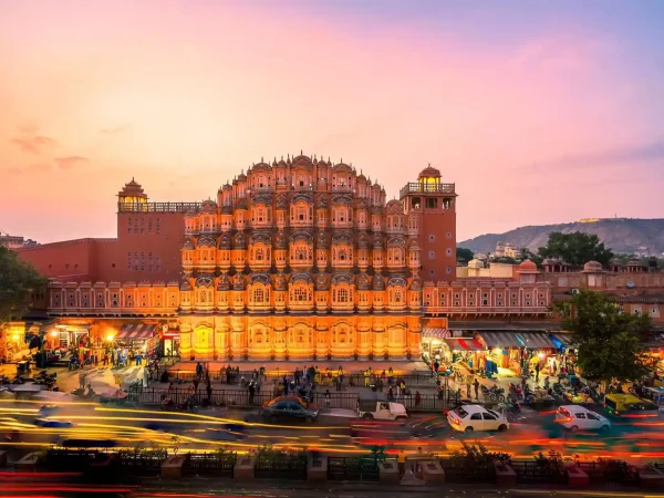 Hawa Mahal, Jaipur: Illuminated palace with pink facade and intricate latticework at sunset.
