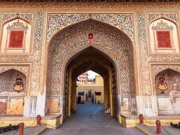 The image shows a large, ornate gateway, richly decorated with intricate floral and geometric patterns.