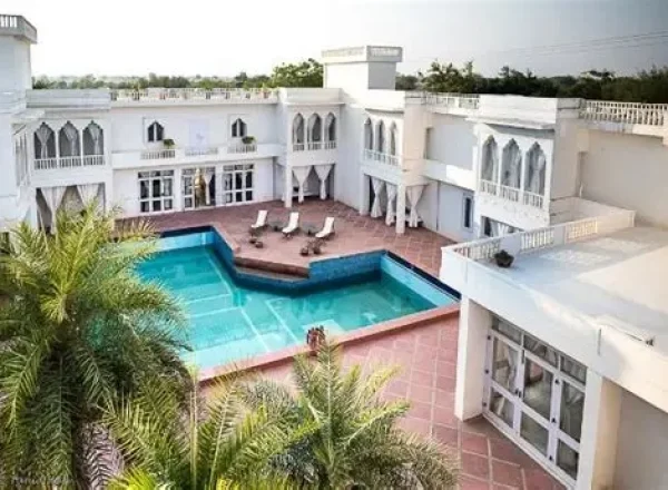 Exterior of Savista Retreat building with a pool and lounge chairs.